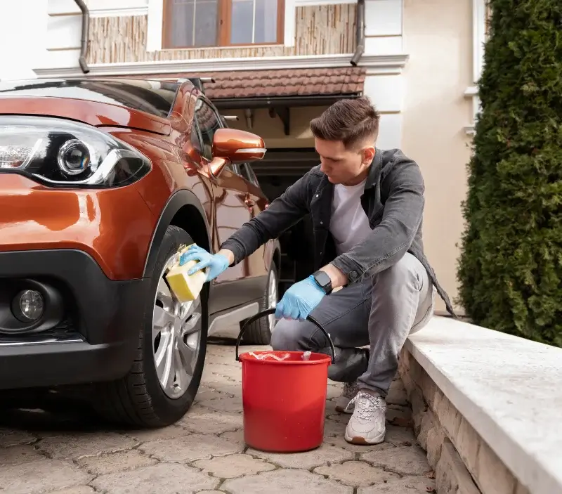 Lavage auto à domicile Saint-Germain-le-Vasson : professionnel intervenant sur un véhicule